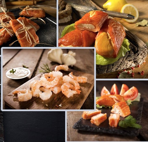 Verschiedene zubereitete Meeresfrüchte: geräucherter Lachs, Garnelen, auf Holz- und Schieferbrettern, präsentiert mit Knoblauch und Zitrone. – Fishing Adventure GmbH